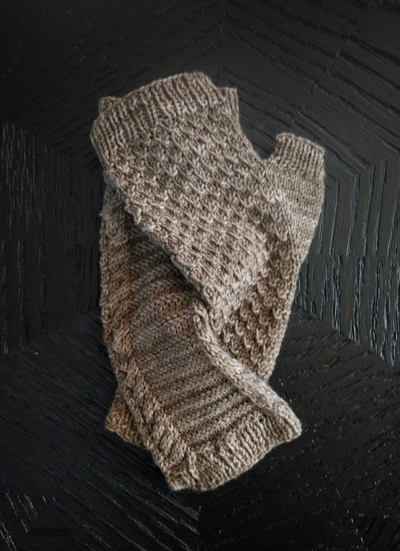 A pair of snakeskin-textured fingerless mitts in pale olive green